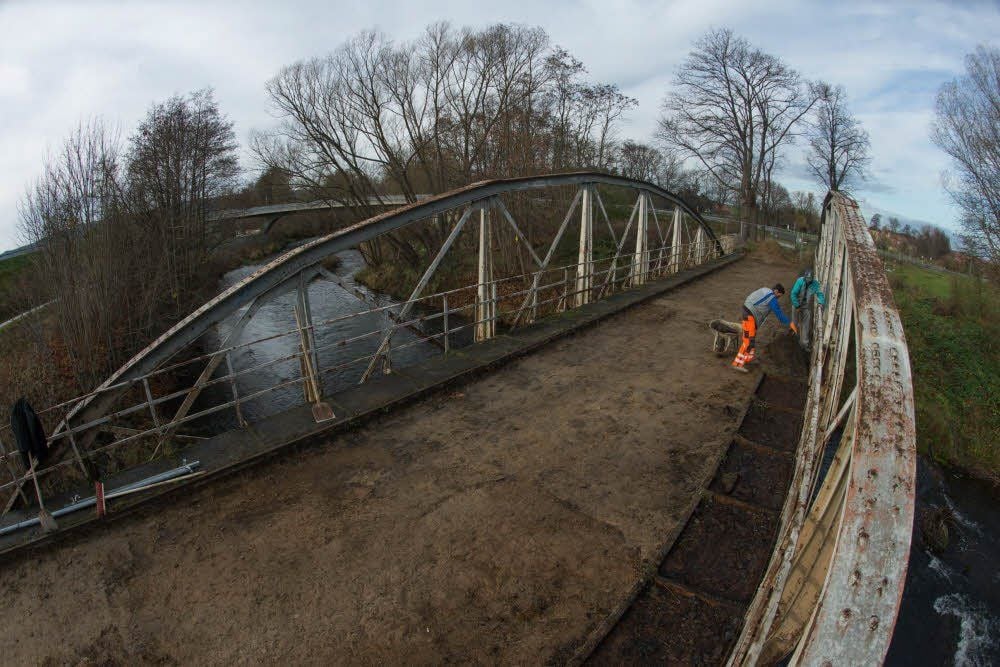 Mitarbeiter der Thalenser Firma RST tragen von der Brücke Fahrbahn und Fußweg ab.