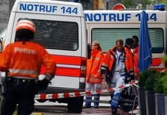 Angehörige der Zürcher Polizei und Sanitäter warten am Montag (05.07.2004) vor dem Bürogebäude der Zürcher Kantonalbank (ZKB) am Tessinerplatz in Zürich, nachdem es in den Räumlichkeiten der ZKB am Morgen zu einer Schießerei gekommen ist. (Foto: dpa)