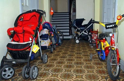 Kinderwagen und Fahrräder stehen in einem Treppenhaus. (FOTO: DPA)