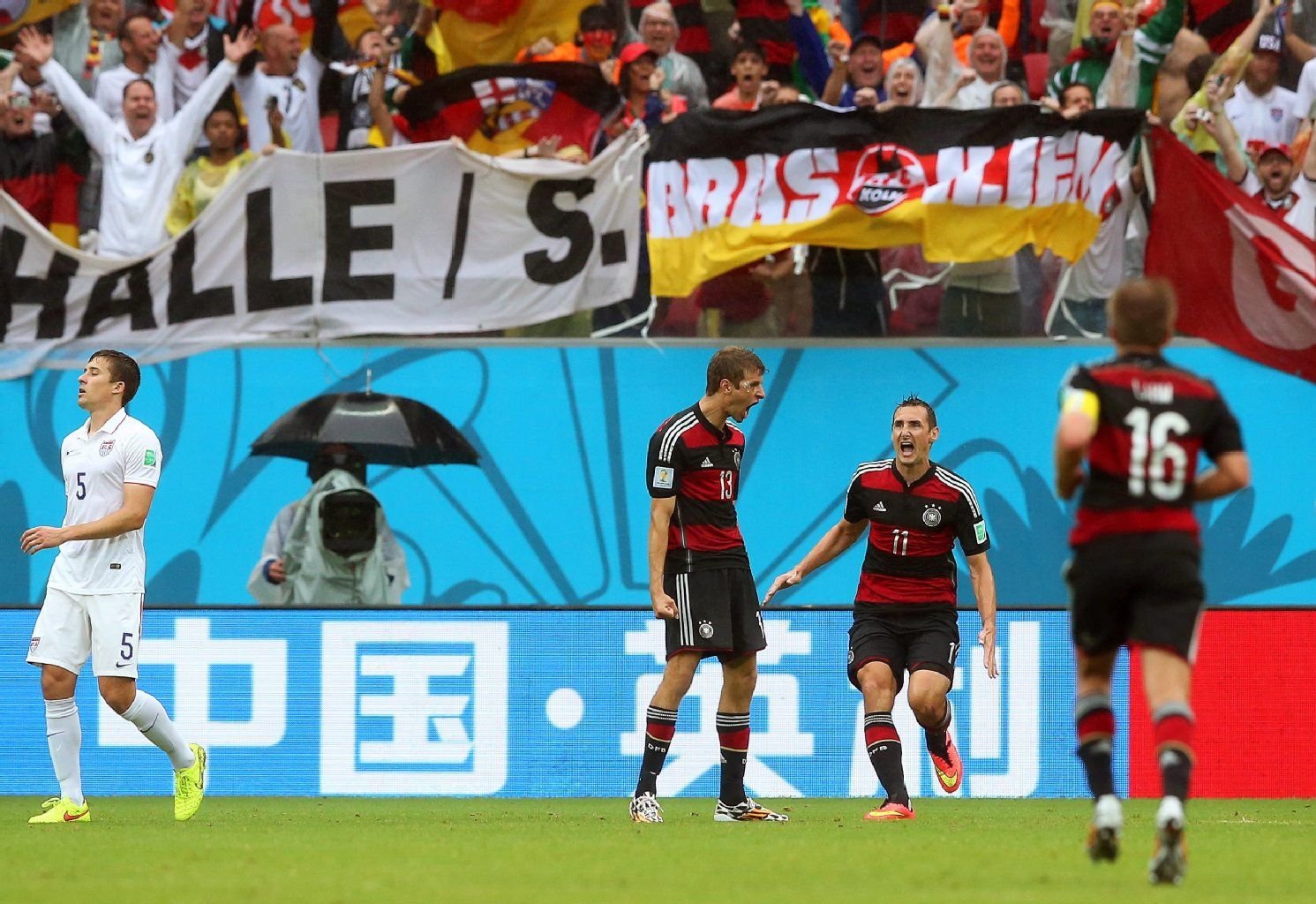 Thomas Müller und Miroslav Klose jubeln vor der "Halle/S."-Fahne.