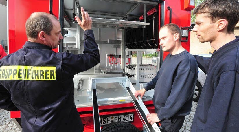 Wehrleiter Uwe Thalheim (links) weist seine Feuerwehrleute am neu angeschafften Tragkraftspritzenfahrzeug vor dem Beladen ein.