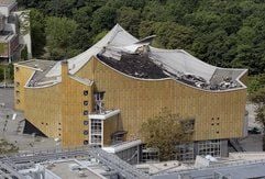 Polizeibeamte und Fachleute untersuchen in Berlin das durch einen Brand am Dienstag zerstörte Dach der Philharmonie. Nach ersten Angaben ist der große Saal nicht in Mitleidenschaft gezogen und der Brand durch Reparaturarbeiten am Dach verursacht worden. (Foto: dpa)
