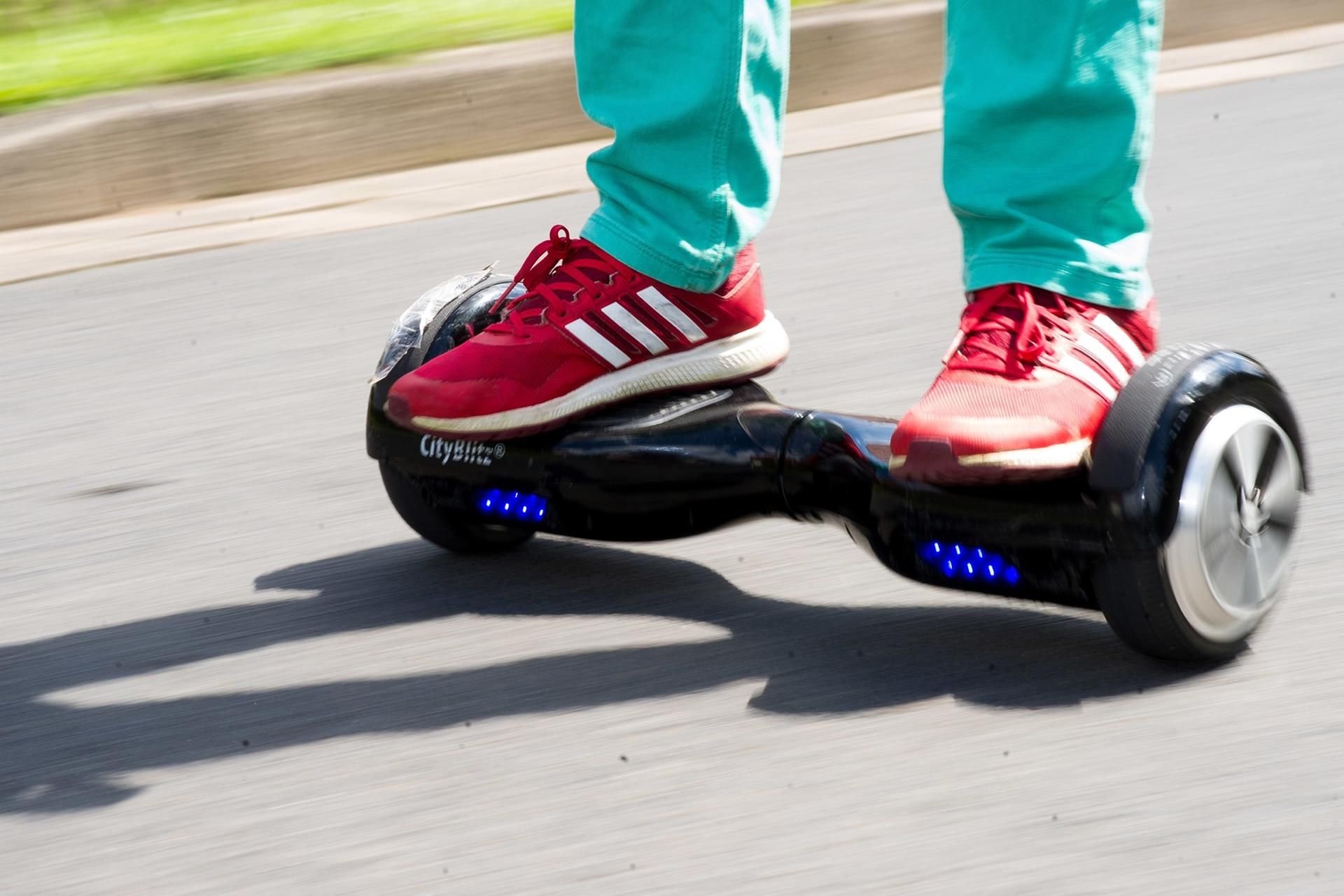 Ein Junge fährt mit einem Hoverboard auf einer Straße. Eine gesetzliche Regelung ähnlich der für Elektro-Tretroller gibt es noch nicht.