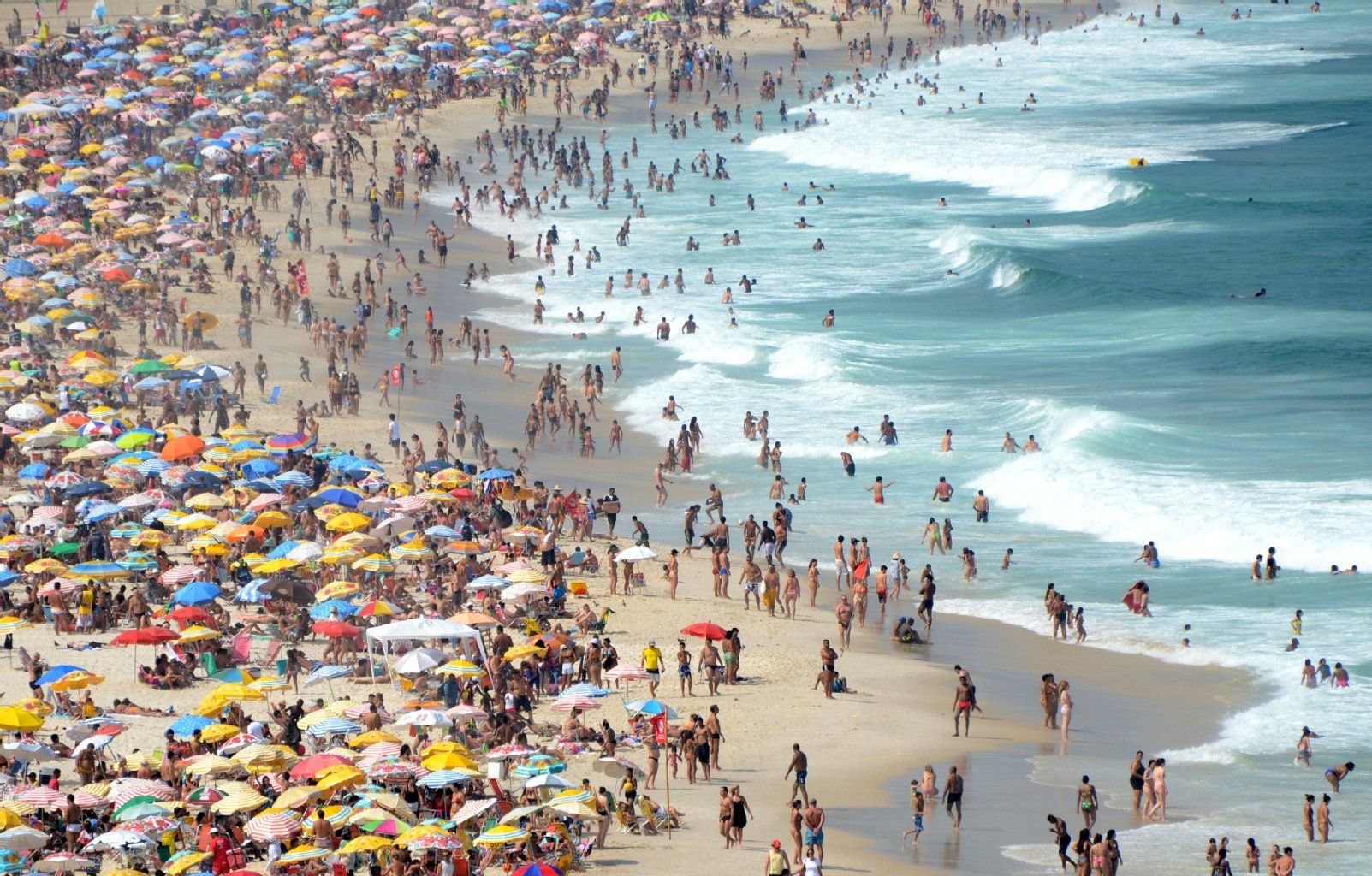 Am Strand an der berühmten Copacabana in Rio de Janeiro (Brasilien) baden tausende Menschen.