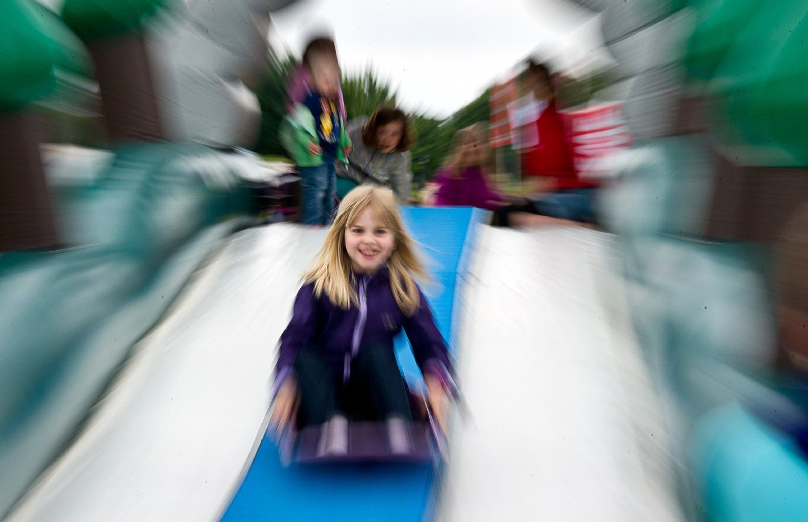 Die kleine Mia rutscht am 01.06.2014 im Elbauenpark in Magdeburg (Sachsen-Anhalt) beim Pusteblumenfest, welches anlässlich des Internationalen Kindertags stattfindet.