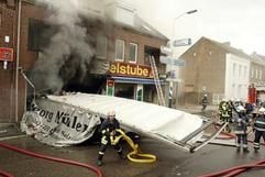 Feuerwehrleute stehen vor dem Heck des Lastwagens, der in den Einkaufsmarkt in Kerkrade in den südlichen Niederlanden gerast und einen Brand ausgelöst hatte. (Foto: dpa)