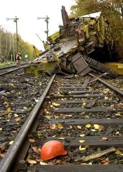 Der Helm eines Bahnarbeiters liegt am Sonntag auf den Gleisen vor einem völlig zerstörten und entgleisten Bauzug. In der Nacht war ein Regionalexpress mit rund 120 Stundenkilometern in der Nähe des Bahnhofes von Panzdorf (Kreis Ostholstein) mit der Baumaschine zusammengeprallt. Bei dem Unfall wurden 15 Menschen zum Teil schwer verletzt.)