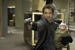 Im neuen Kinofilm «Shoot 'Em Up» hält Smith (Clive Owen) einen Säugling im Arm, während er mit seiner Waffe zielt. (Foto: dpa)