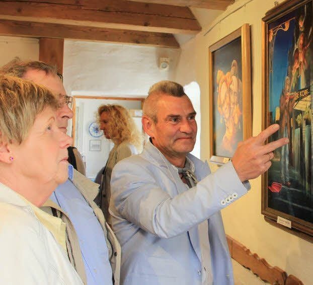 Burkhardt (r.) zeigt Ulrich und Brigitta Reimann Details seiner Bilder.
