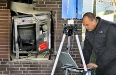 Ein Mitarbeiter des Landeskrimalamts (LKA) vermisst am Dienstag (14.03.2006) in Bochum einen gesprengten Bankautomaten an einer Sparkasse mit einem computergestützten Laserscanner. (Foto: dpa)