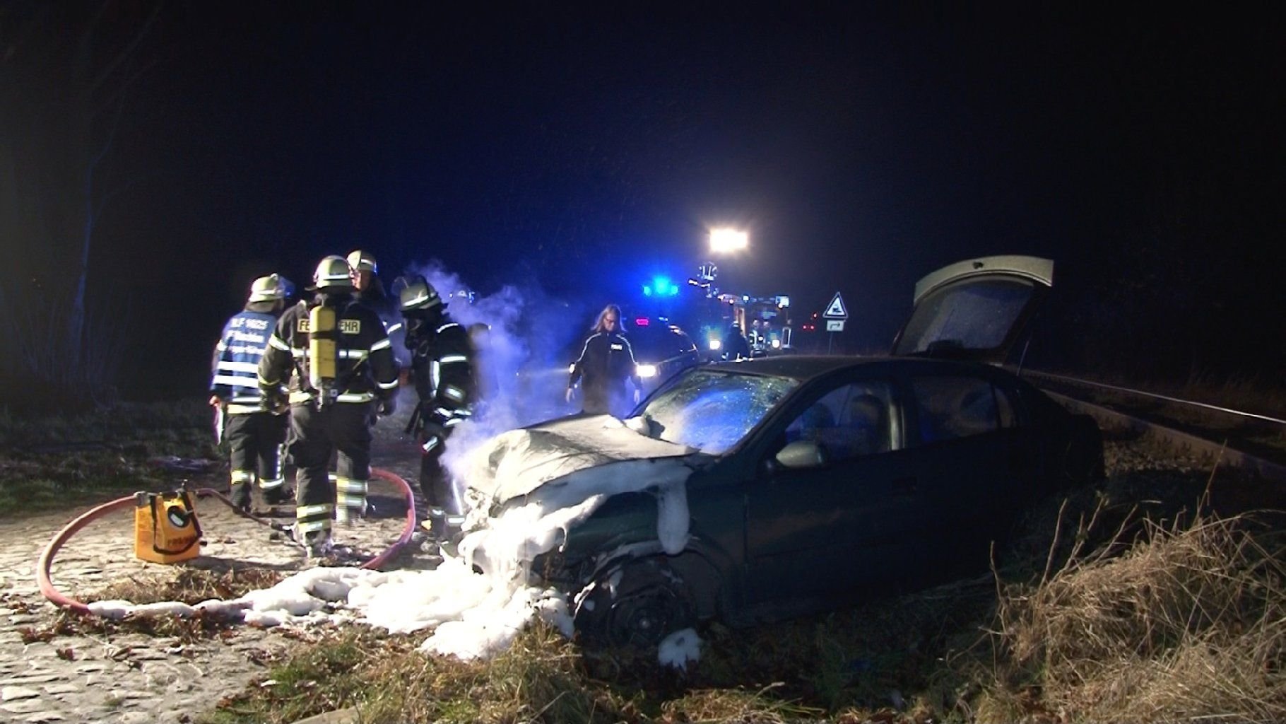 Feuerwehrleute löschen das Fahrzeuig nach dem Unfall in Wanzleben