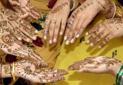 Pakistanische Mädchen zeigen ihre Hände, die sie sich anlässlich des Festes des Fastenbrechens (Eid al-Fitr) bemalt haben. (Foto: dpa)