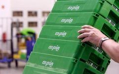 Ein Mitarbeiter trägt grüne Briefkisten durch die Halle des Sortierzentrums der Pin Mail AG in Berlin. (Foto: ddp)
