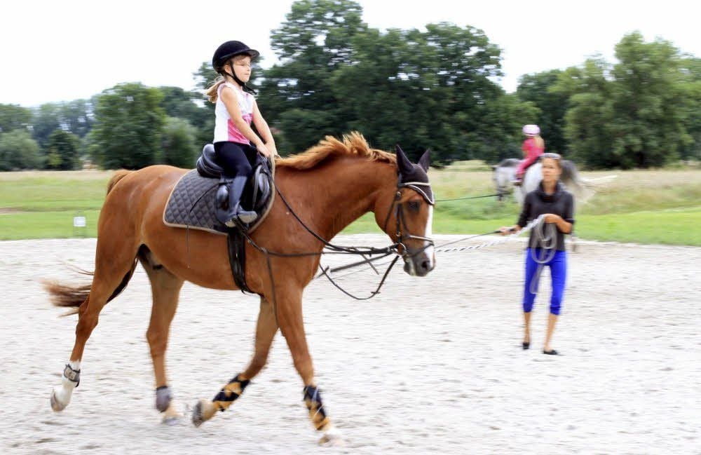 Ines Laude führt Pferd Amigo an der Longe, während Eva reitet.