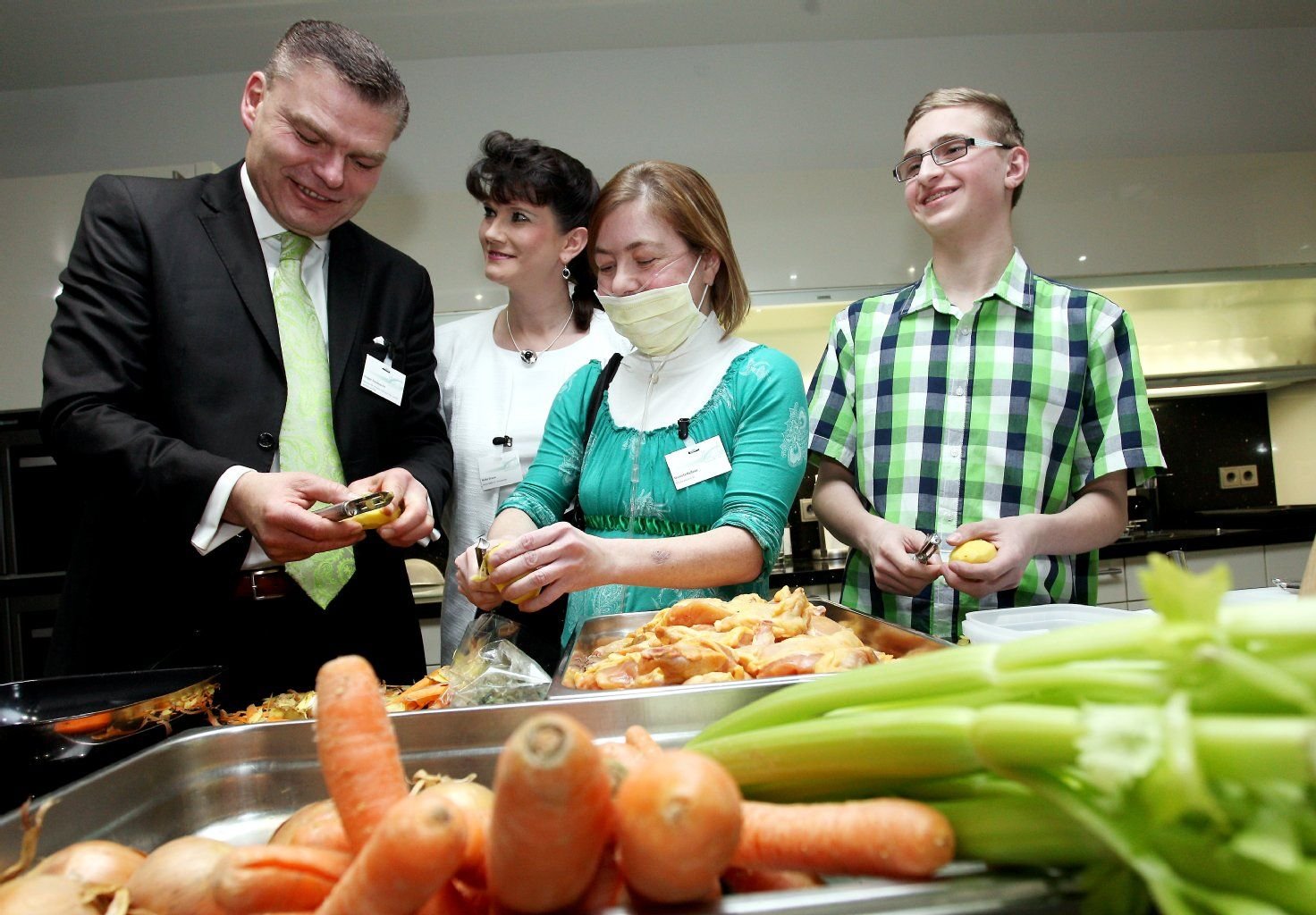 Innenminister Holger Stahlknecht (l.) zusammen mit der Vereinsvorsitzenden Heike Grasse (2.v.l.), Daniela Hellner (3.v.l.) und Philip Tänzer (13) bei den Kochvorbereitungen.