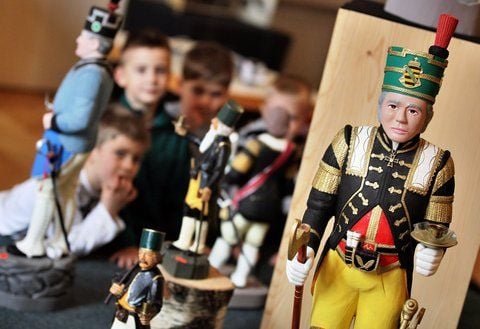 Kinder betrachten geschnitzte Bergmänner aus heutiger Zeit in der Ausstellung «Schnitzerland Erzgebirge» in Annaberg-Buchholz. (FOTO: DPA)