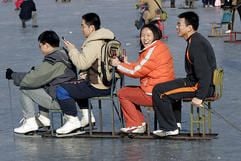 Drei Männer und eine Frau, das gibt Streit: Junge Chinesen amüsieren sich auf einem zugefrorenen See in Peking. (Foto: dpa)