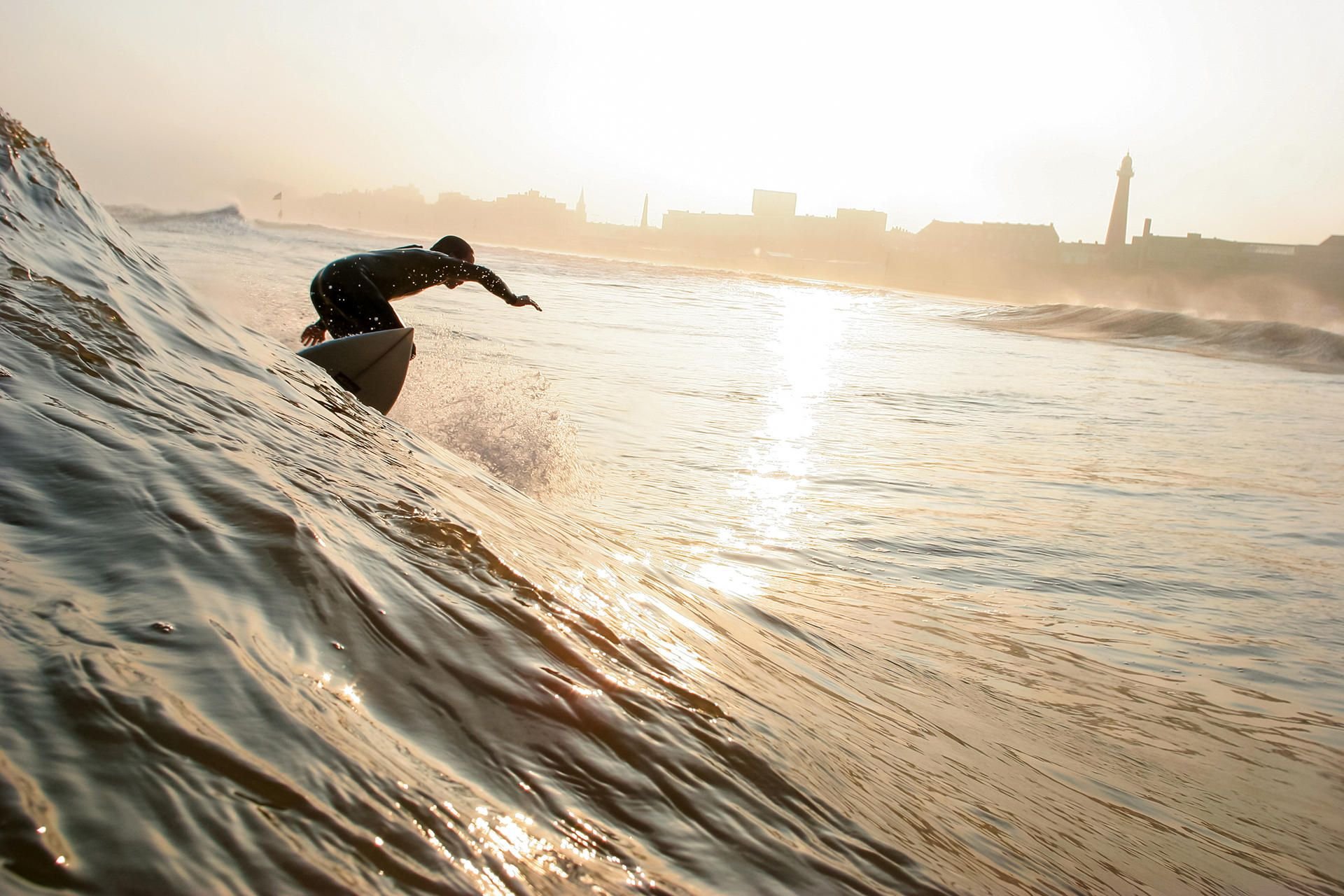 Surfen in den Nordseewellen an der Küste von Scheveningen - einst war der Ort ein mondänes Seebad.