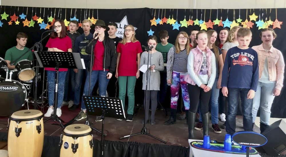 Die Schüler der Arbeitsgemeinschaft Theater und Musik und die Schulband interpretieren das Lied „Wir ziehen in den Frieden“.