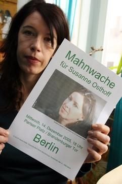 Die Schwester der im Irak entführten Susanne Osthoff, Anja Osthoff, zeigt am Freitag (09.12.2005) in ihrer Wohnung in München den Ausdruck eines Plakates, mit dem für eine Mahnwache am 14. Dezember in Berlin geworben wird. (Foto: dpa)