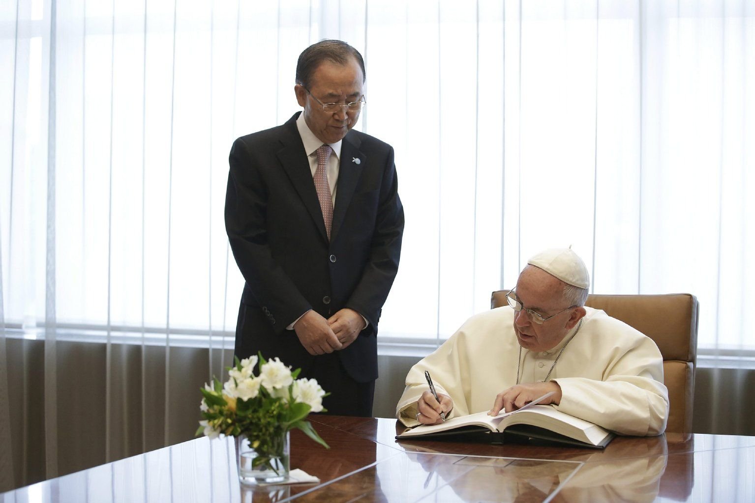 Vor Kanzlerin Angela Merkel war Papst Franziskus zu Gast bei den Vereinten Nationen. Hier trägt er sich neben UN-Generalsekretär Ban Ki Moon in ein Gästebuch ein.
