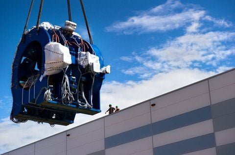 Ein Kran hieft das 41 Tonnen schwere Dreiwalzen-Streckwalzenaggregat für das Rohrforschungszentrum ins Innere des Werks. (FOTO: DPA)