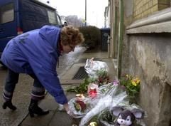 Eine Frau legt am Freitag vor dem Haus in Zerbst, in dem die sechsjährige Malin am Vortag tot gefunden worden war, Blumen nieder. (Foto: dpa)