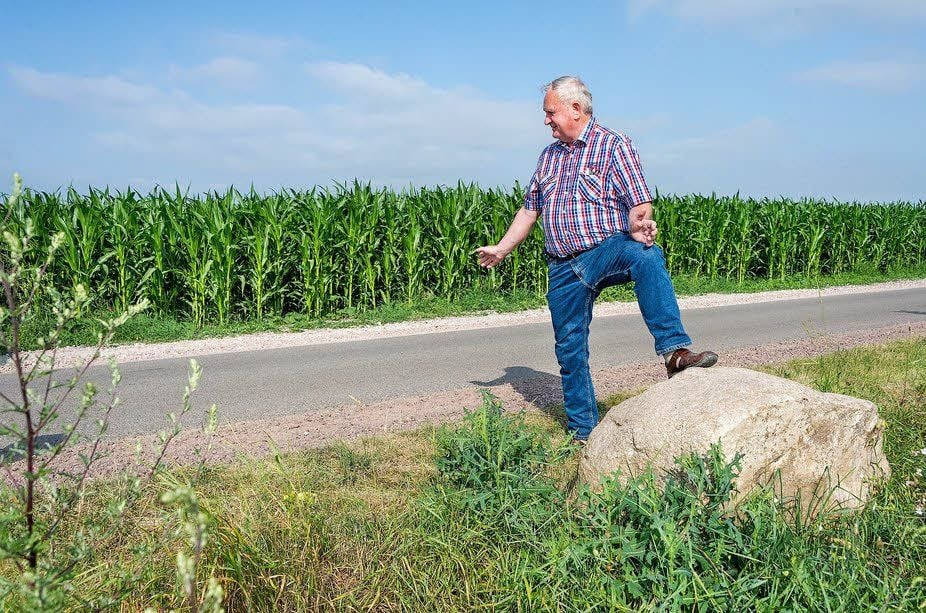 Geusas Ortsbürgermeister Hans-Joachim Koziel am Hinweisstein. Er verweist auf den verschwundenen „Püppchenstein“, der am anderen Wegesrand lag. Der zwei Tonnen schwere Felsen ist wie vom Erdboden verschluckt.