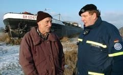 Vor einem polnischen Binnenschiffs, das vor zehn Monaten auf einer Elbwiese in Schnackenburg (Kreis Lüchow-Dannenberg) gestrandet war, sprechen am Mittwoch (21.01.2004) Kapitän Wlodzimierz Rosik (57, l.) und Hans-Hermann Mietz vom Technischen Hilfswerk (THW) über die jetzt beginnenden Bergungsarbeiten. Acht Männer vom THW sollen zunächst die technischen Vorbereitungen treffen. Sie wollen in den kommenden acht Tagen das Frachtschiff wieder in die Elbe hieven. Der Kapitän hatte wegen Hochwassers die Hafeneinfahrt verfehlt. (Foto: dpa)