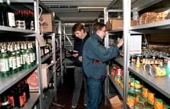 Zwei junge Männer entdecken im Keller der Zentrale des Amtes für Nationale Sicherheit in Berlin Warenregale mit Lebensmitteln und Spirituosen (Archivfoto vom 15.01.1990). (Foto: dpa)