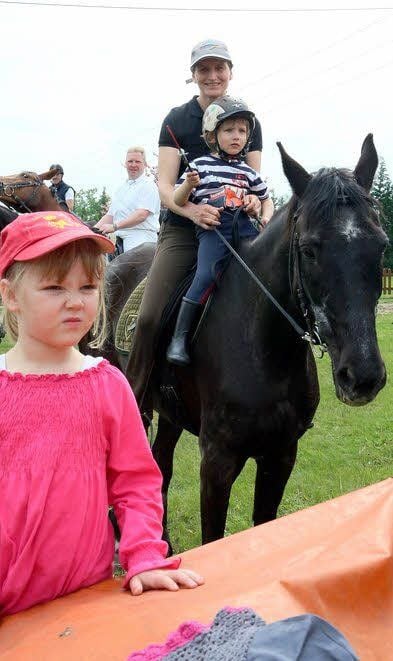 In voller Montur darf die vierjährige Joris auf dem Pferd bei Mutti sitzen.