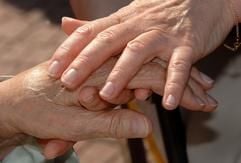 Eine Betreuerin streichelt während des «Betreuten Urlaubs» für Alzheimerkranke in Boltenhagen einer Patientin die Hand (Foto: dpa)