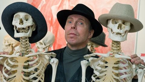 Gunther von Hagens steht im Plastinarium im brandenburgischen Guben zwischen zwei Skeletten. (FOTO: DPA/ARCHIV)