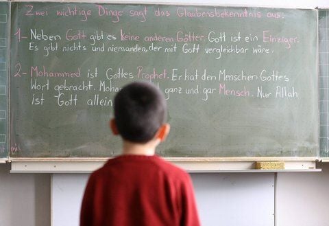 Ein Schüler aus einer Grundschule in Niedersachsen liest während des Islam-Unterrichts von der Tafel ab. (ARCHIVFOTO: DDP)