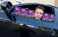 Student Max Raschke blickt an einer Straße in Osnabrück aus dem Fenster eines Autos durch Flyer seiner eigenen Tauschaktion (www.studikarre.de) hindurch. (Foto: dpa)