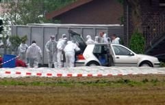 Spezialkräfte in Schutzanzügen stehen am Freitag (09.05.2003) vor einem Geflügelhof in Schwalmtal (Kreis Viersen). Wegen des Verdachts auf Geflügelpest sollen auf dem Hof zehntausende Masthähnchen getötet werden. (Foto: dpa)