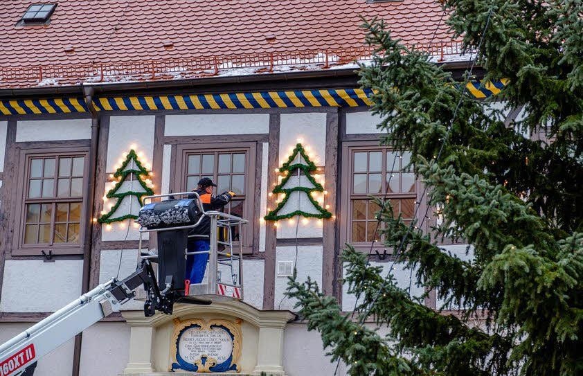 Mitarbeiter des Bauhofes schmücken das Rathaus und den Baum.