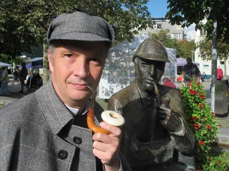 Olaf Maurer, Präsident der deutschen Sherlock-Holmes-Gesellschaft, in Meiringen neben dem Sherlock-Holmes-Denkmal. Foto: Christiane Oelrich