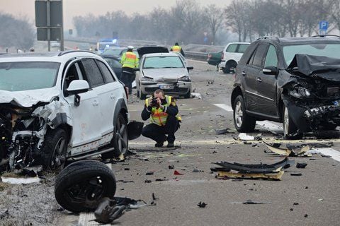 Ein Polizist fotografiert nach einem Unfall auf der Bundesstraße 30 nahe Ulm (Baden-Württemberg) die Unglücksstelle. (FOTO: DPA)