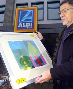 Einen handsignierten und nummerierten Kunstdruck hält Klaus Hennen am Montag (01.12.2003) vor einer Aldi-Filiale in Düsseldorf in den Händen. Zum Stück-Preis von 12,99 Euro bot der Mülheimer Discounter Aldi Süd unter anderem Werke des Beuys-Schülers Felix Droese an. Innerhalb kürzester Zeit waren in zahlreichen Filialen die Drucke ausverkauft. (Foto: dpa)