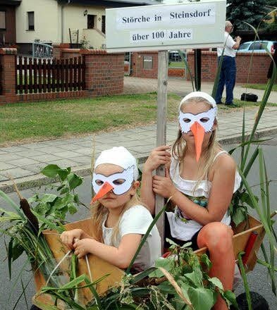Mehr als 100 Jahre nisten in Steinsdorf Störche. Als größere „Küken“ ließen sich Cheyenne (l.) und Jona-Mylee Schüler im Wagen ziehen.