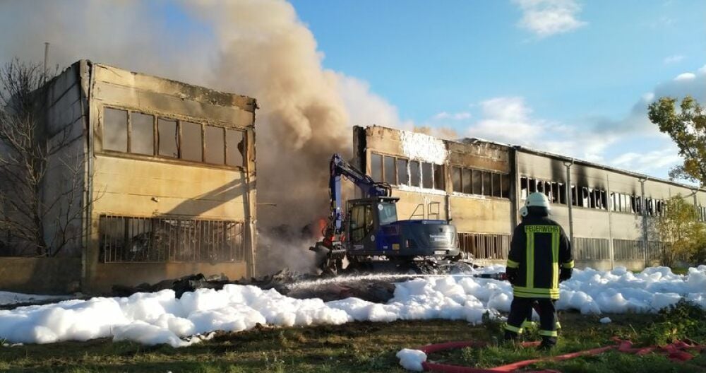 Die brennende Lagerhalle in Globig. Der THW-Bagger ist im Einsatz.