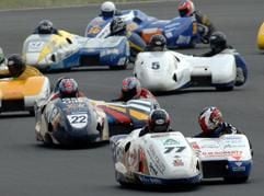 Start zum vierten Lauf der Motorrad-Weltmeisterschaft für Seitenwagen am Sonntag (10.07.2005) auf dem Schleizer Dreieck. Vorn mit Nummer 77 das in der WM führende Team Tim und Tristan Reeves aus Großbritannien, die den WM-Lauf in Schleiz gewinnen. Hinter ihnen mit Nummer 22 Jörg Steinhausen mit seinem Beifahrer Trevor Hopkinson. (Foto: dpa)