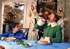 Buddy (Will Ferrell, r) benimmt sich in dem neuen Kinofilm «Buddy - Der Weihnachtself» unter den Augen eines Kindes am Essenstisch daneben (Szenenfoto). Buddy war einst als kleiner Junge unbemerkt am Heiligen Abend in den Geschenkesack des Weihnachtsmannes gestiegen - und prompt als blinder Passagier in das Märchenreich am Nordpol gelangt, wo er von Elfen aufgezogen wurde. Eines Tages - Buddy ist seiner Ersatz-Familie längst über den Kopf gewachsen - können die Elfen ihm nicht mehr verschweigen, dass er keiner von ihnen, sondern ein Mensch ist. Buddy macht sich daraufhin zur Weihnachtszeit auf den Weg nach New York City, um seine leiblichen Eltern zu suchen. (Foto: dpa)
