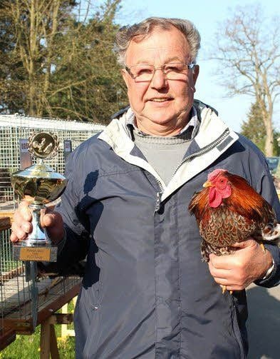 Werner Reim mit Wanderpokal und seinem Spitzenkräher, der zu kaiserlichen Ehren kam.