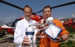 Kardiotechniker Alois Phillip (l) und Notarzt Markus Zimmermann präsentieren am Freitag (05.05.2006) im oberpfälzischen Regensburg vor einem Rettungshubschrauber die weltweit kleinste Herz-Lungen-Maschine. (Foto: dpa)