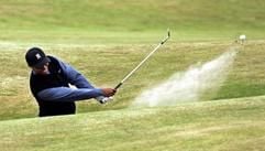 Tiger Woods schlägt den Ball aus dem Bunker. (Foto: dpa)