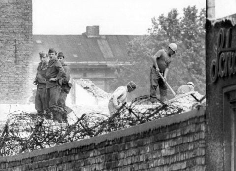 Ostberliner Bauarbeiter sind unter strenger Bewachung durch Vopos am 01.06.1966 in Berlin mit dem Abriss von Grenzhäusern an der Bernauer Straße beschäftigt. (FOTO: ARCHIV/DPA)
