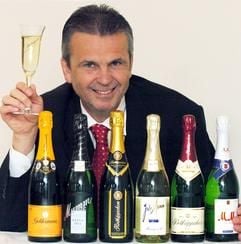 Geschäftsführer Gunter Heise an einem Tisch mit den verschiedenen Sektmarken, die zum Unternehmen Rotkäppchen-Mumm-Sektkellereien Freyburg gehören. (Foto: dpa)