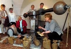 Im Museum "Alte Münze" in Stolberg (Harz) lassen sich Besucherinnen vom Metallrestaurator Ulrich Sieblist (vorn, links) und von Dr. Monika Lücke (r), wissenschaftlichen Mitarbeiterin am Institut für Geschichte der Martin-Luther-Universität Halle-Wittenberg, an einem Balancier (Spindelprägewerk) die Prägung von Münzen erklären. (Foto: dpa)